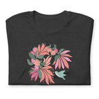 Hummingbird among coral tropical flowers on a t-shirt in dark grey heather, folded close-up of the design – Kate Spain design