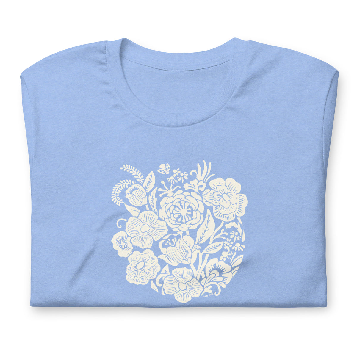 Meadowsweet woodblock-style bouquet of wildflowers on a t-shirt in heather Carolina blue, folded close-up of the design – Kate Spain design