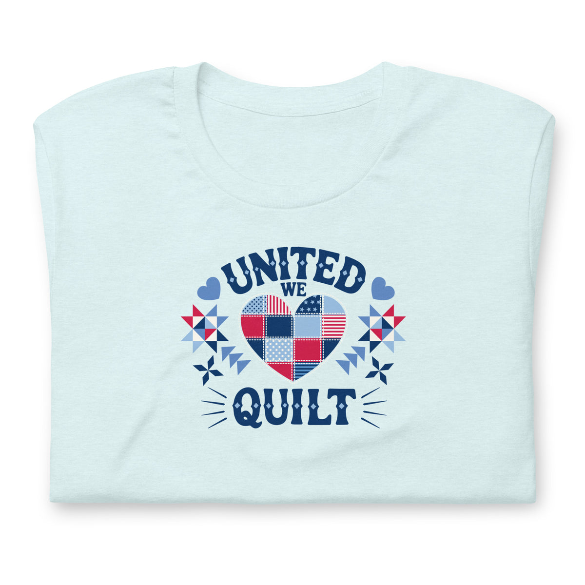 Quilters United quilt badge in red, white and blue on a t-shirt in heather ice blue, folded close-up of the design – Kate Spain design for Pat Sloan