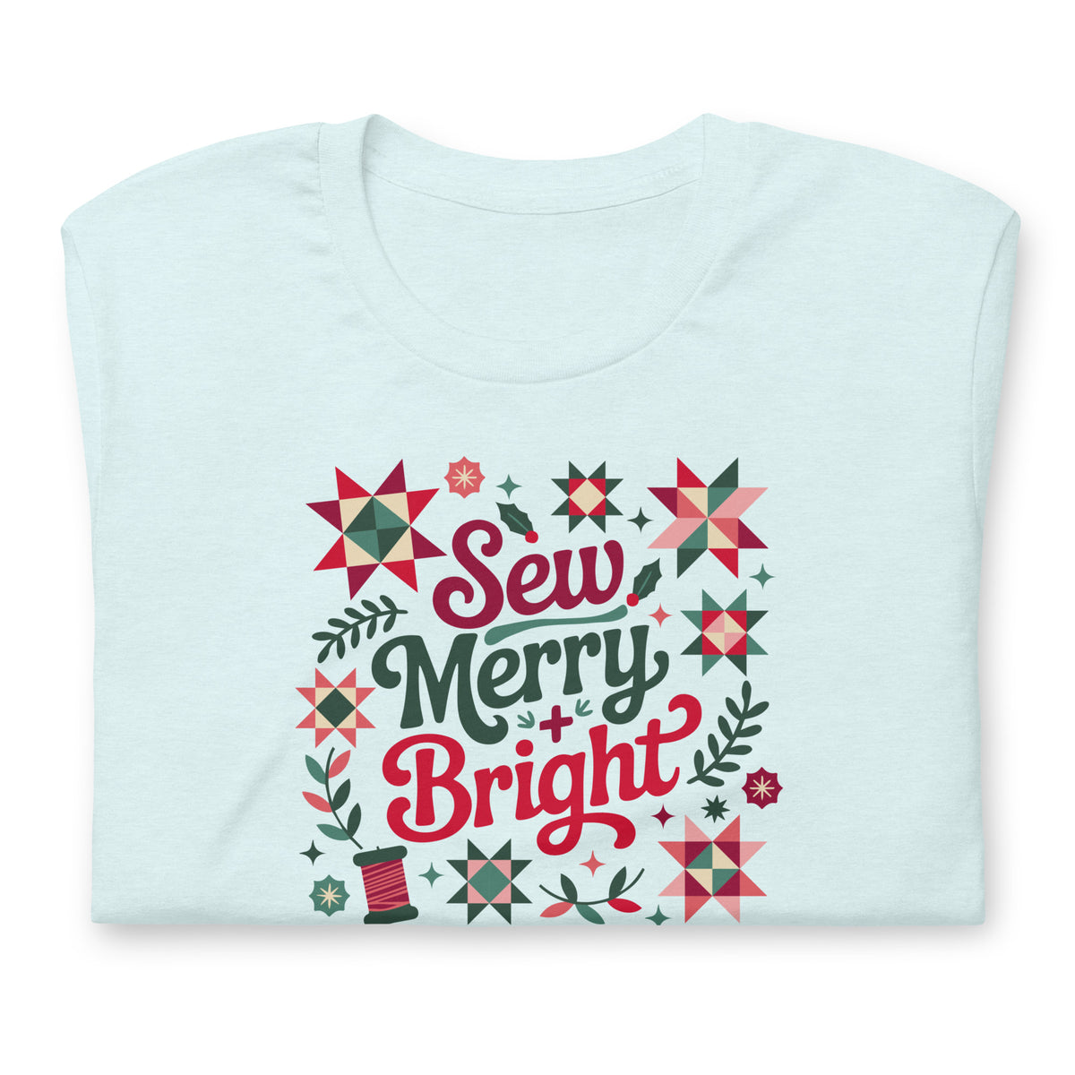 Sew Merry + Bright lettering with quilt stars and holly on a staple t-shirt in heather ice blue, folded close-up of the design – Kate Spain design for Pat Sloan