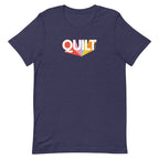 Moda QUILT logo with orange, pink, blue and yellow rays on a staple t-shirt in heather navy, front view – Kate Spain design