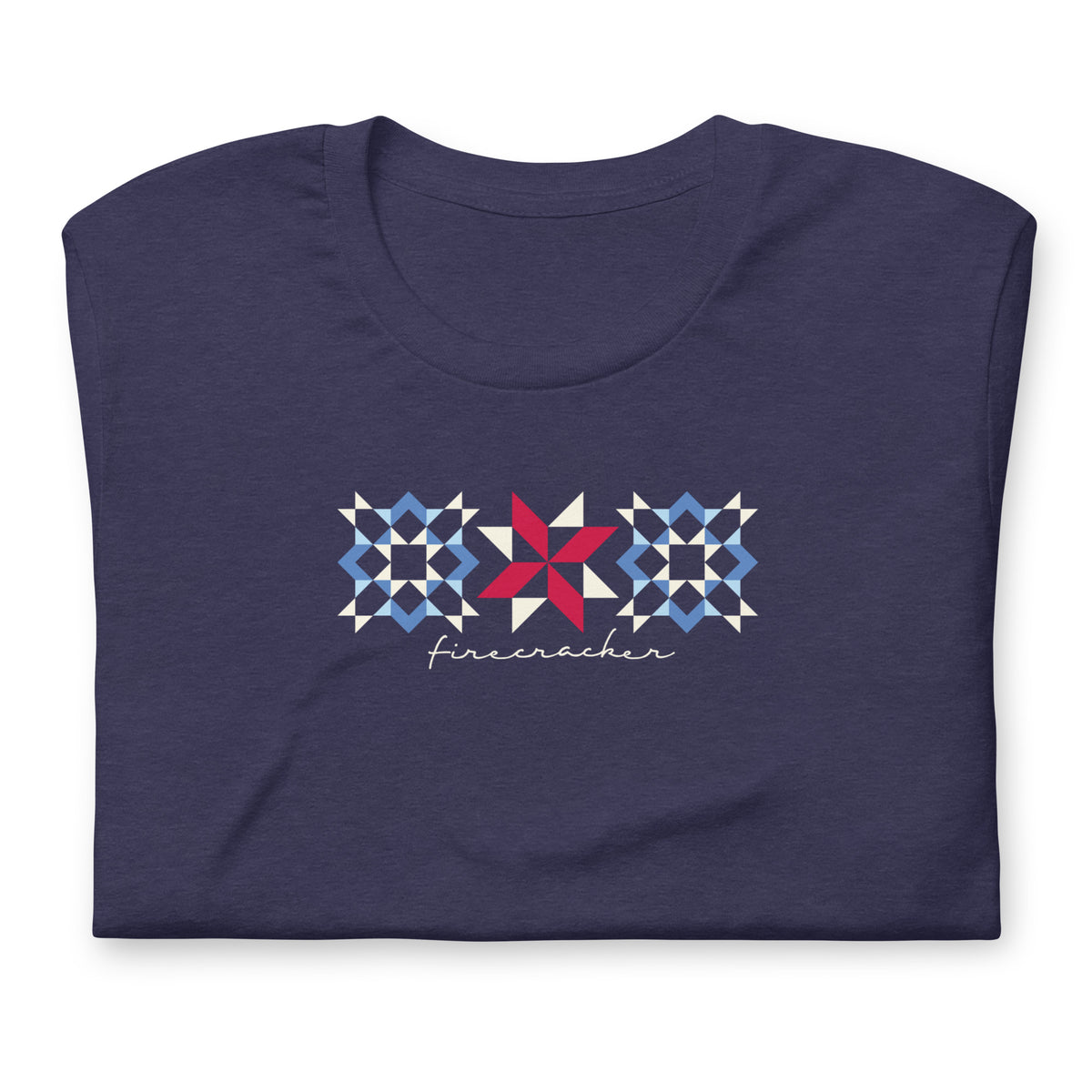 Firecracker quilt-block stars with script lettering in red, white and blue on a t-shirt in heather navy, folded close-up of the design – Kate Spain design for Pat Sloan