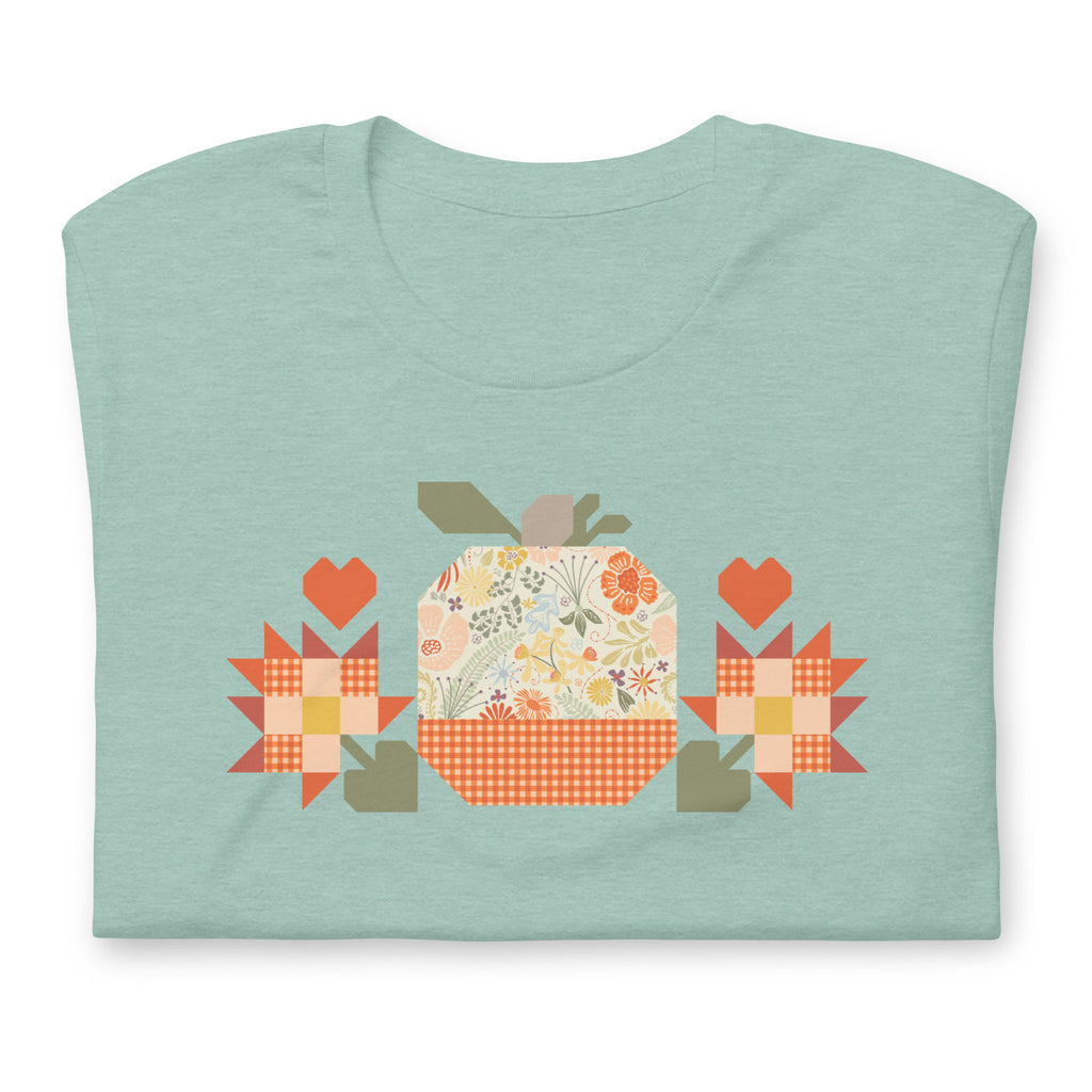 Falling for Fall patchwork pumpkin with quilt-block stars and hearts on a t-shirt in heather prism jade, folded close-up of the design – Kate Spain design for Pat Sloan
