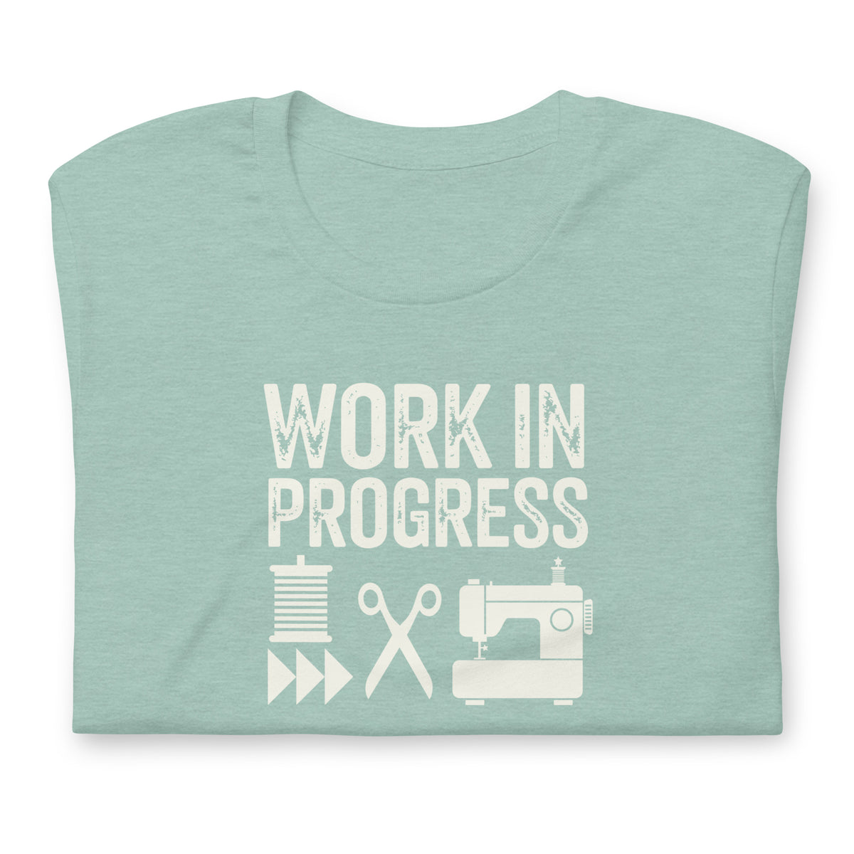 Work in Progress Mod distressed lettering with thread, scissors and sewing machine on a t-shirt in heather prism jade, folded close-up of the design – Kate Spain design for Pat Sloan