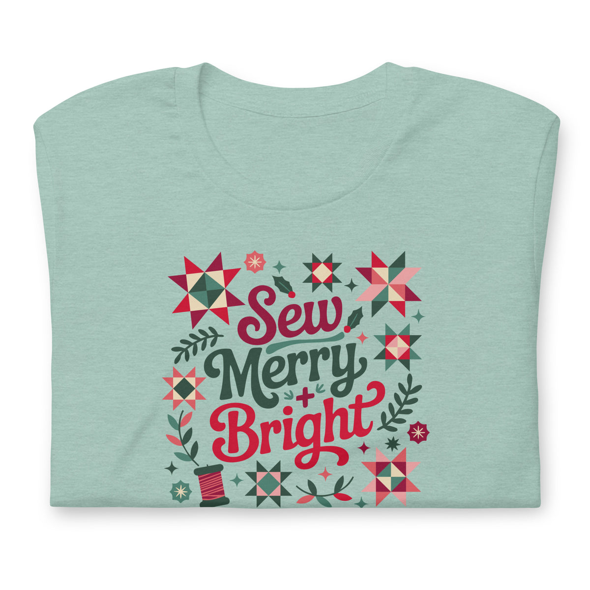 Sew Merry + Bright lettering with quilt stars and holly on a staple t-shirt in heather prism jade, folded close-up of the design – Kate Spain design for Pat Sloan