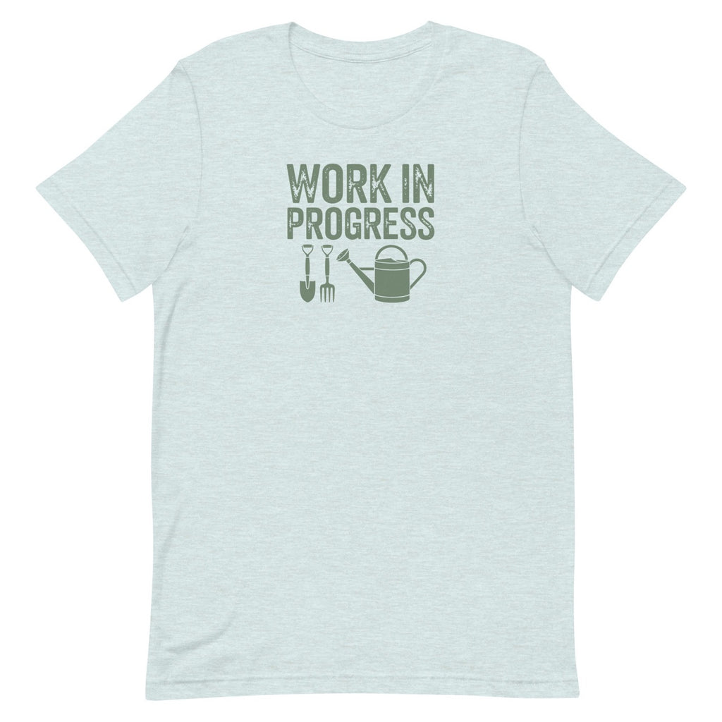Garden Work in Progress distressed lettering with a shovel, pitchfork and watering can on a t-shirt in heather prism ice blue, front view – Kate Spain design