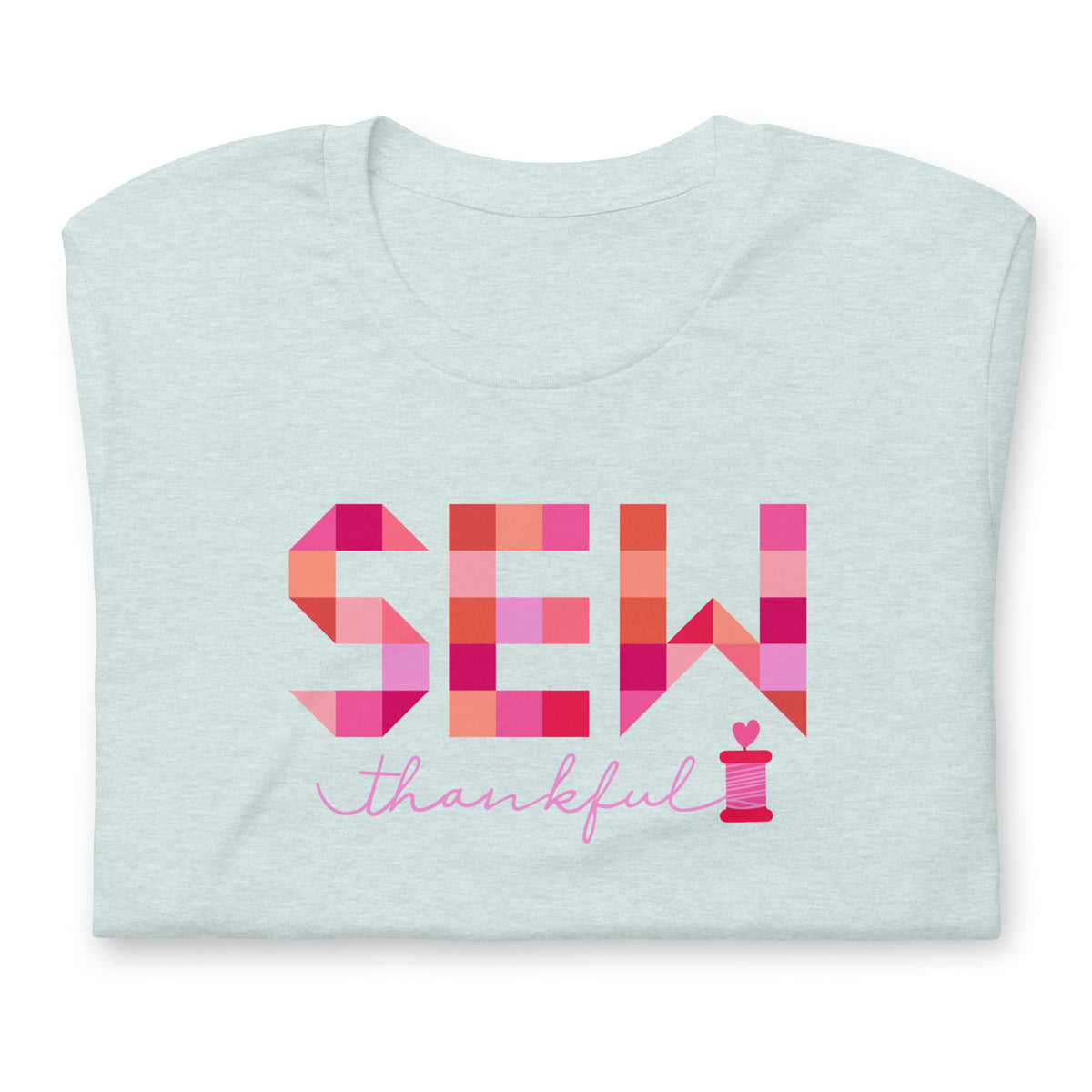 Sew Thankful patchwork lettering with a heart-topped thread spool on a t-shirt in heather prism ice blue, folded close-up of the design – Kate Spain design for Pat Sloan