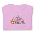 Bloom woodblock-style flowers with a butterfly, ladybug and bee on a t-shirt in lilac, folded close-up of the design – Kate Spain design