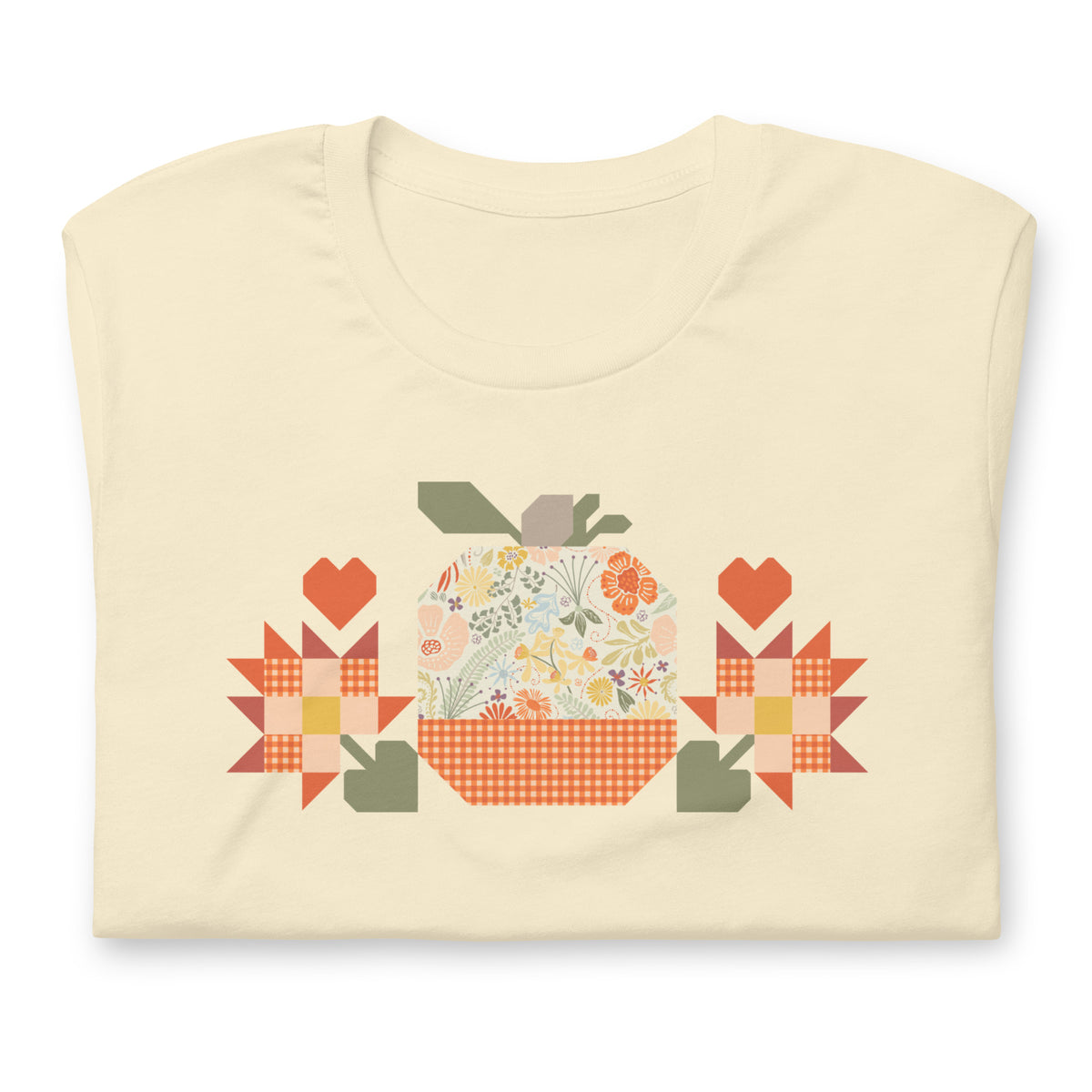 Falling for Fall patchwork pumpkin with quilt-block stars and hearts on a t-shirt in vintage white, folded close-up of the design – Kate Spain design for Pat Sloan