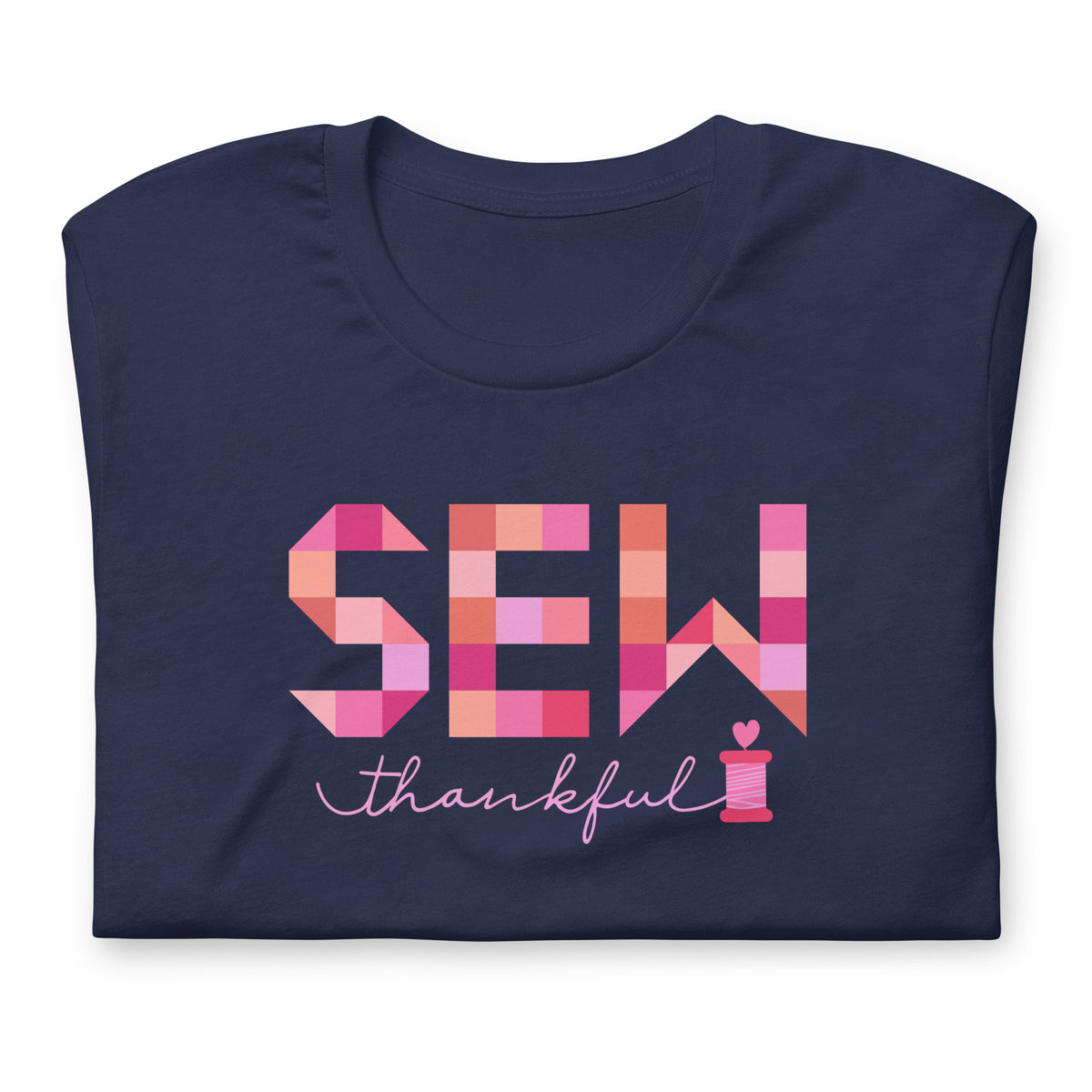 Sew Thankful patchwork lettering with a heart-topped thread spool on a t-shirt in navy, folded close-up of the design – Kate Spain design for Pat Sloan