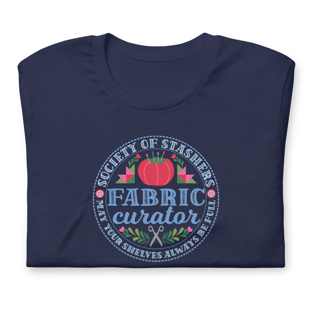 Fabric Curator Society of Stashers badge with a tomato pincushion on a t-shirt in navy, folded close-up of the design – Kate Spain design for Pat Sloan