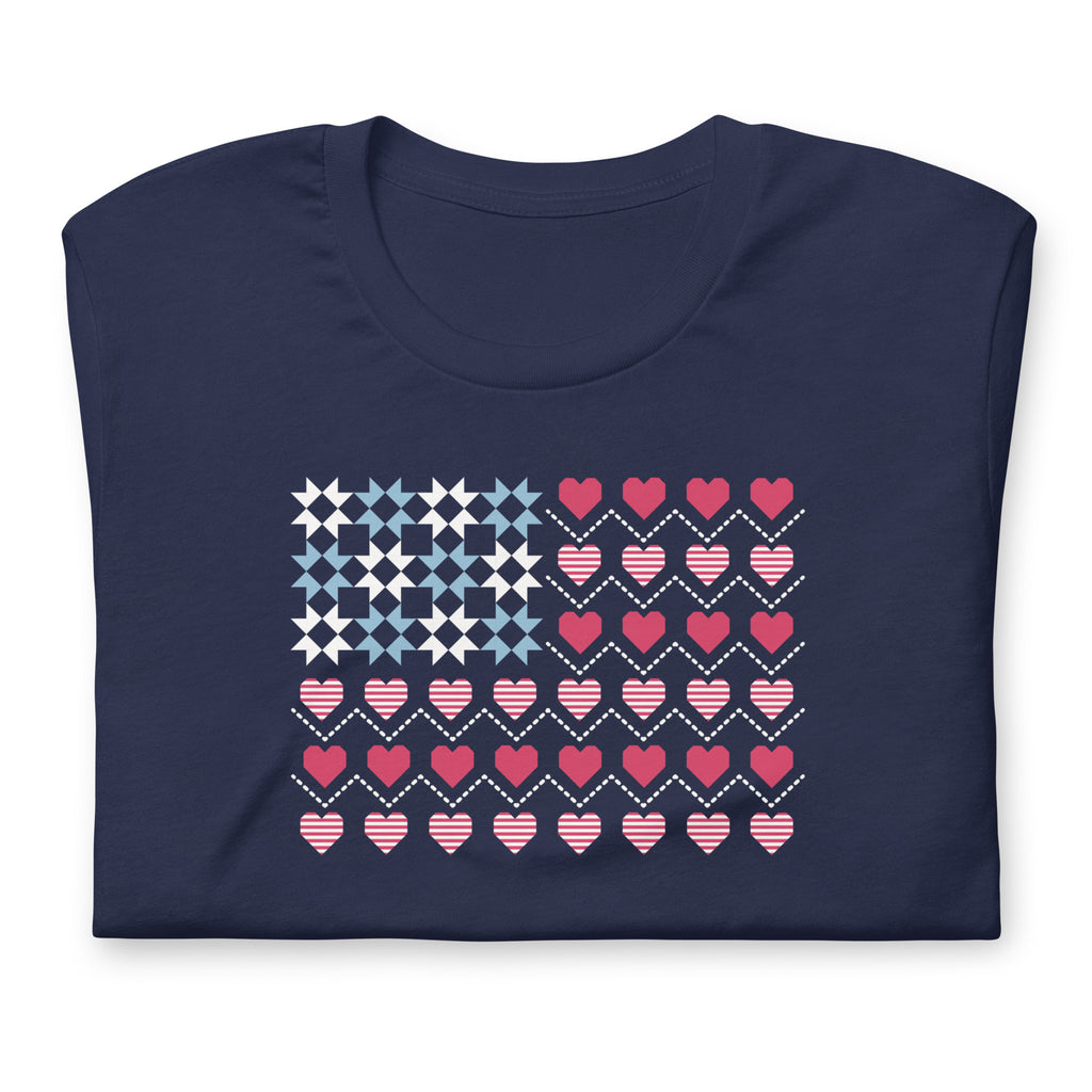 United We Quilt patchwork flag with quilt-block stars and heart stripes on a t-shirt in navy, folded close-up of the design – Kate Spain design for Pat Sloan