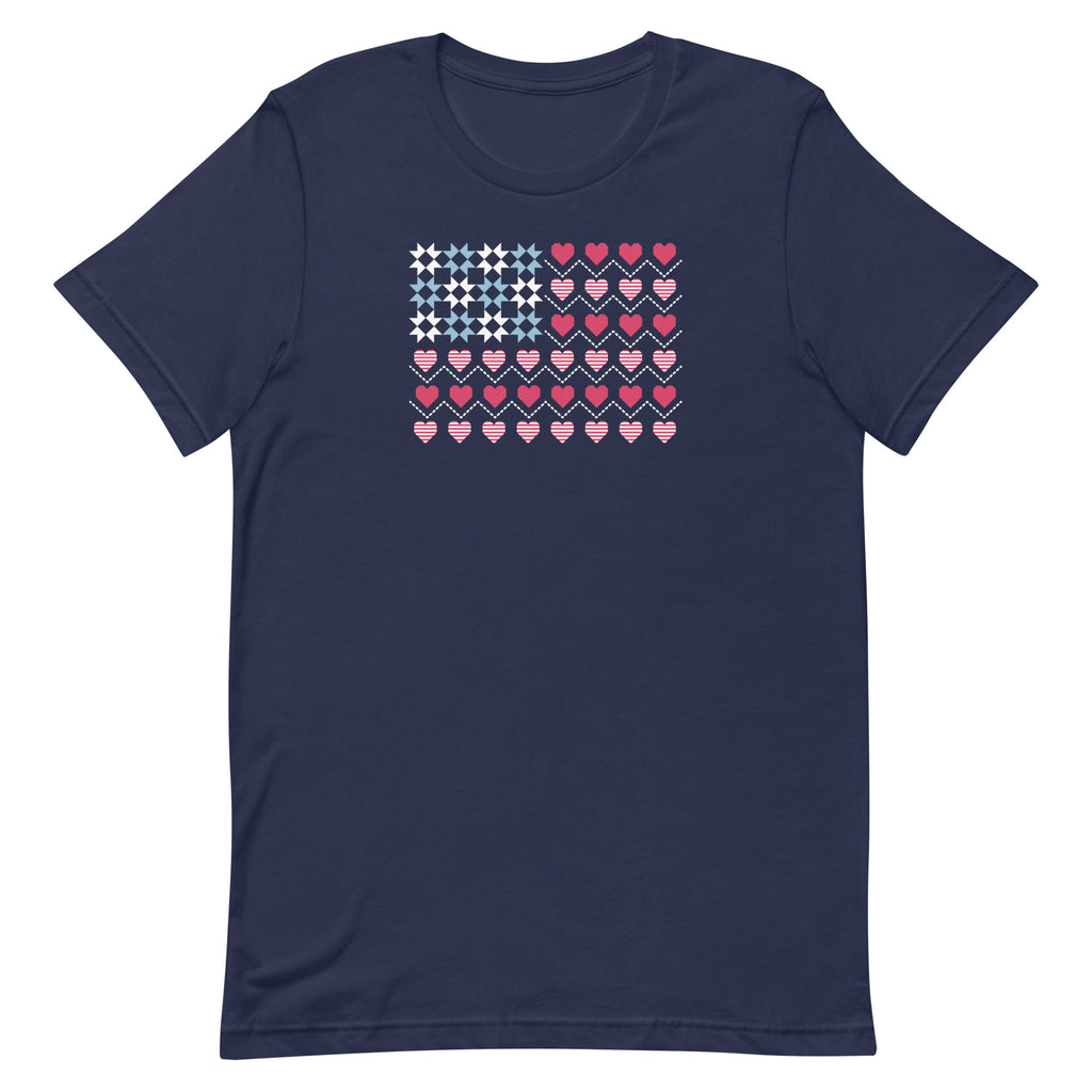 United We Quilt patchwork flag with quilt-block stars and heart stripes on a t-shirt in navy, front view – Kate Spain design for Pat Sloan