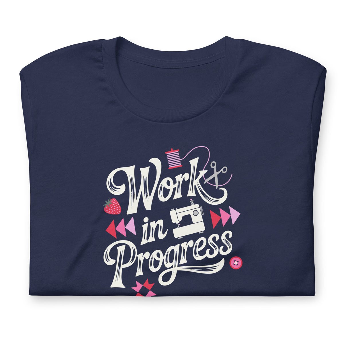 Work in Progress sewing design with flying geese, sewing machine, strawberry and thread spool on a t-shirt in navy, folded close-up of the design – Kate Spain design for Pat Sloan