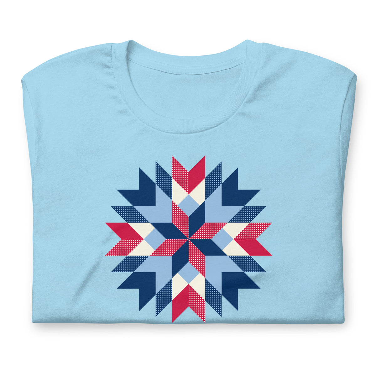 Barn Star quilt block in red, white and blue on a t-shirt in ocean blue, folded close-up of the design – Kate Spain design for Pat Sloan