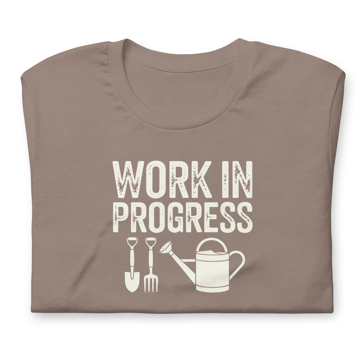 Garden Work in Progress distressed lettering with a shovel, pitchfork and watering can on a t-shirt in pebble, folded close-up of the design – Kate Spain design