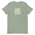 Needs Water + Sunlight hand lettering with leaf and sun accents on a t-shirt in sage, front view – Kate Spain design