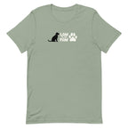 Law of the Paw® logo with seated dog and paw print on a t-shirt in sage, front view – Kate Spain design