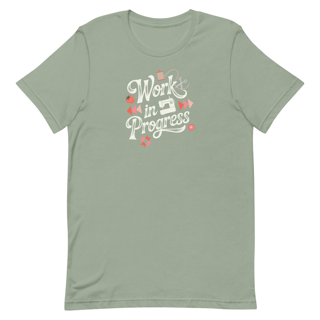 Work in Progress sewing design with flying geese, sewing machine, strawberry and thread spool on a t-shirt in sage, front view – Kate Spain design for Pat Sloan