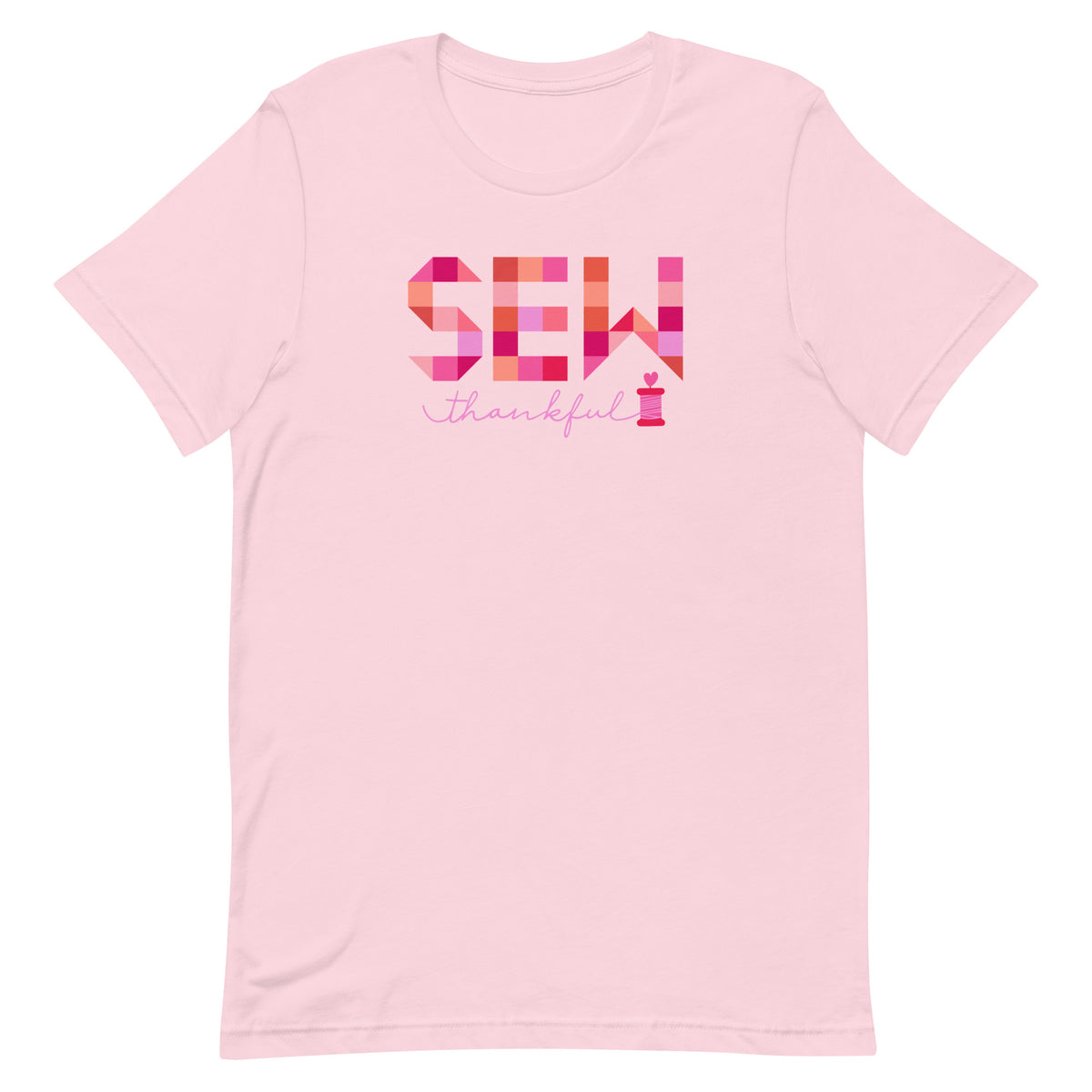 Sew Thankful patchwork lettering with a heart-topped thread spool on a t-shirt in pink, front view – Kate Spain design for Pat Sloan