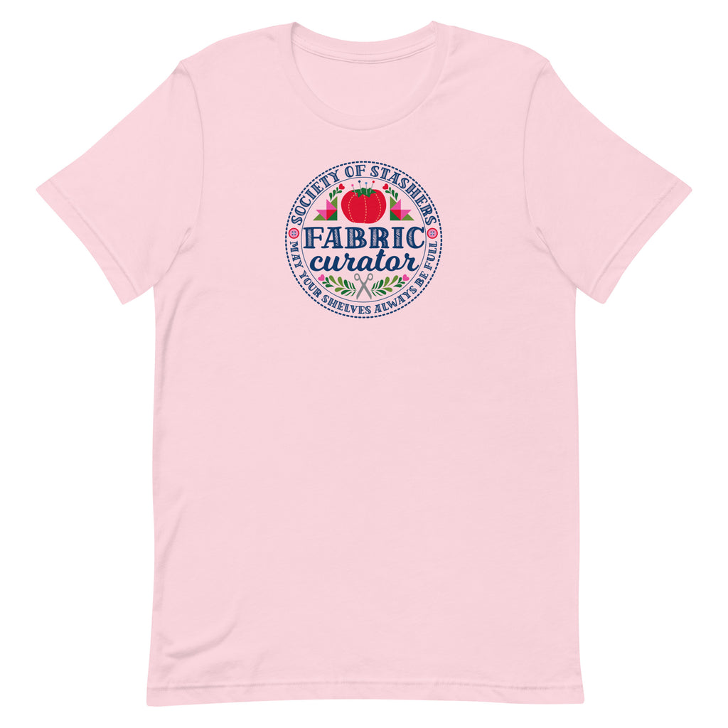 Fabric Curator Society of Stashers badge with a tomato pincushion on a t-shirt in pink, front view – Kate Spain design for Pat Sloan