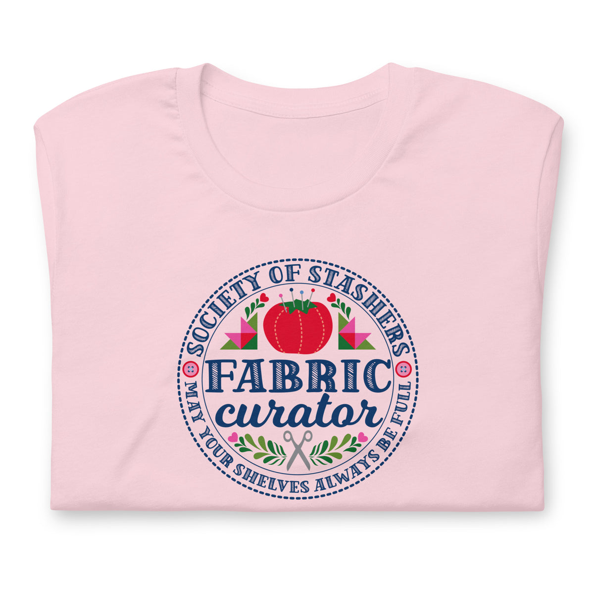 Fabric Curator Society of Stashers badge with a tomato pincushion on a t-shirt in pink, folded close-up of the design – Kate Spain design for Pat Sloan