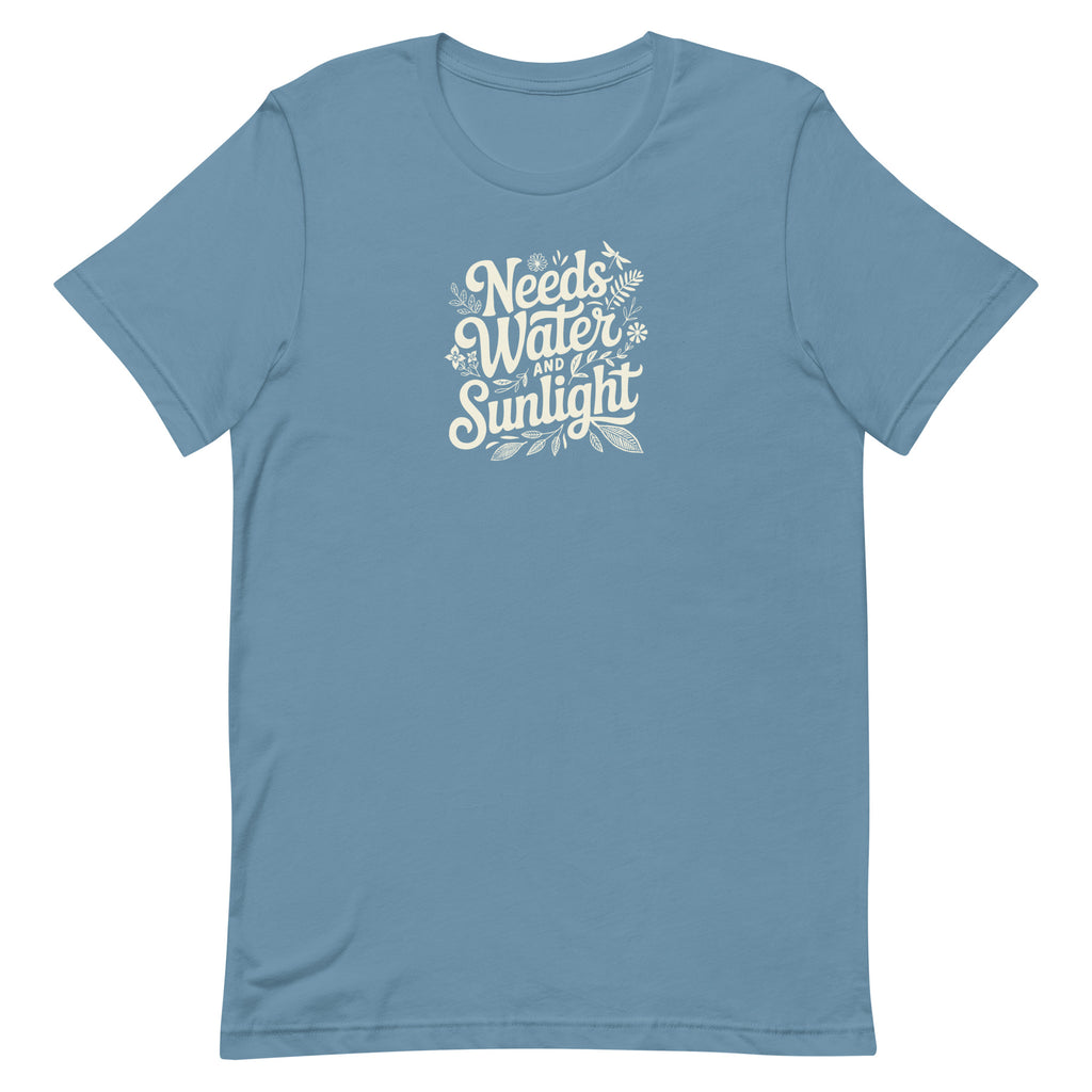 Needs Water + Sunlight hand lettering with leaf and sun accents on a t-shirt in steel blue, front view – Kate Spain design