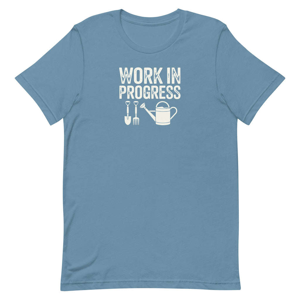 Garden Work in Progress distressed lettering with a shovel, pitchfork and watering can on a t-shirt in steel blue, front view – Kate Spain design