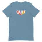 Moda QUILT logo with orange, pink, blue and yellow rays on a staple t-shirt in steel blue, front view – Kate Spain design