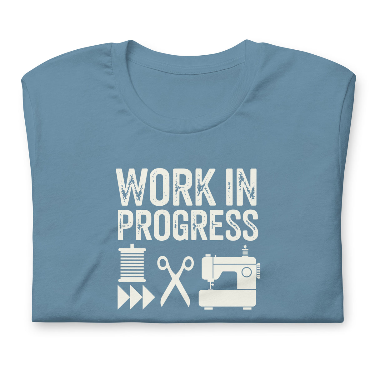 Work in Progress Mod distressed lettering with thread, scissors and sewing machine on a t-shirt in steel blue, folded close-up of the design – Kate Spain design for Pat Sloan