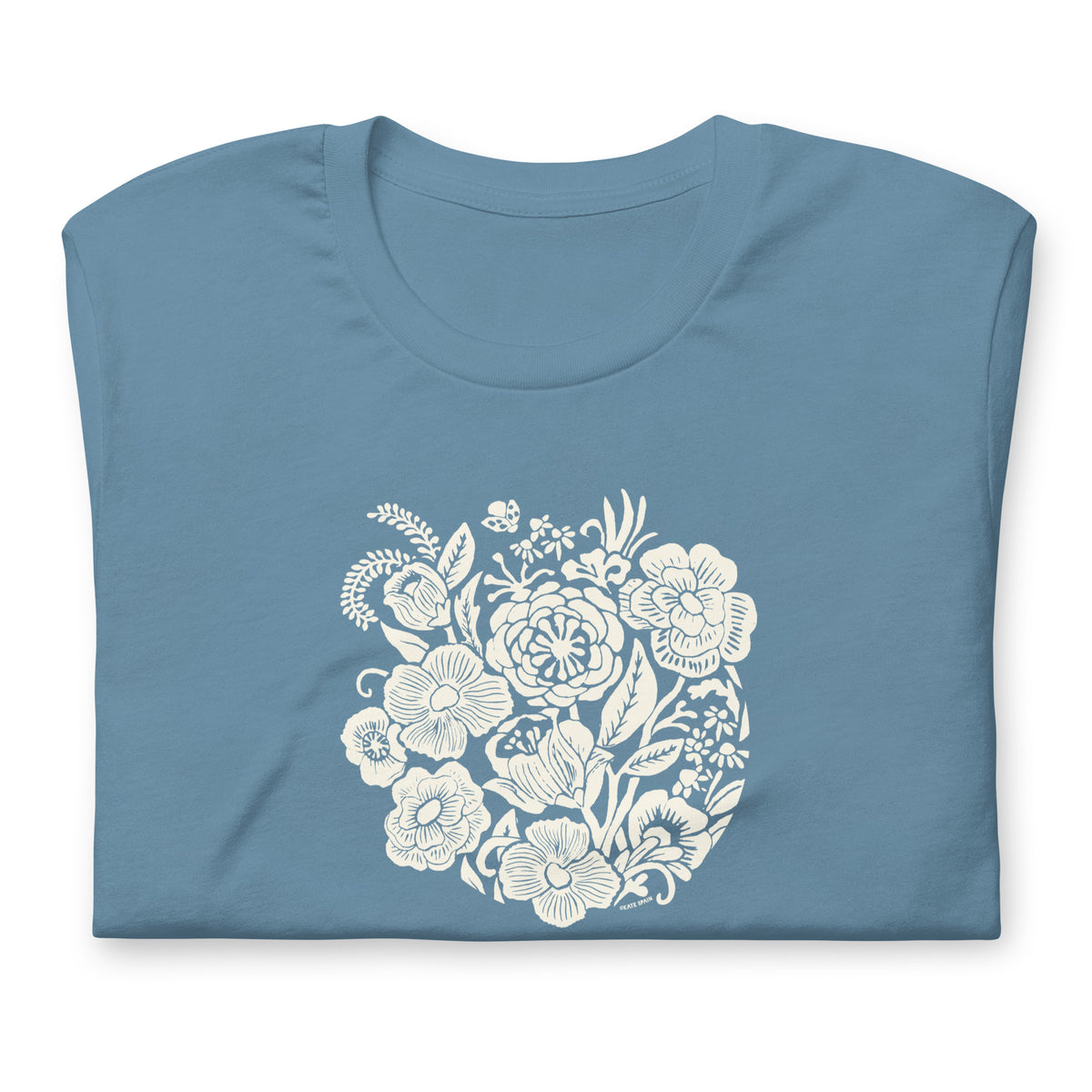 Meadowsweet woodblock-style bouquet of wildflowers on a t-shirt in steel blue, folded close-up of the design – Kate Spain design