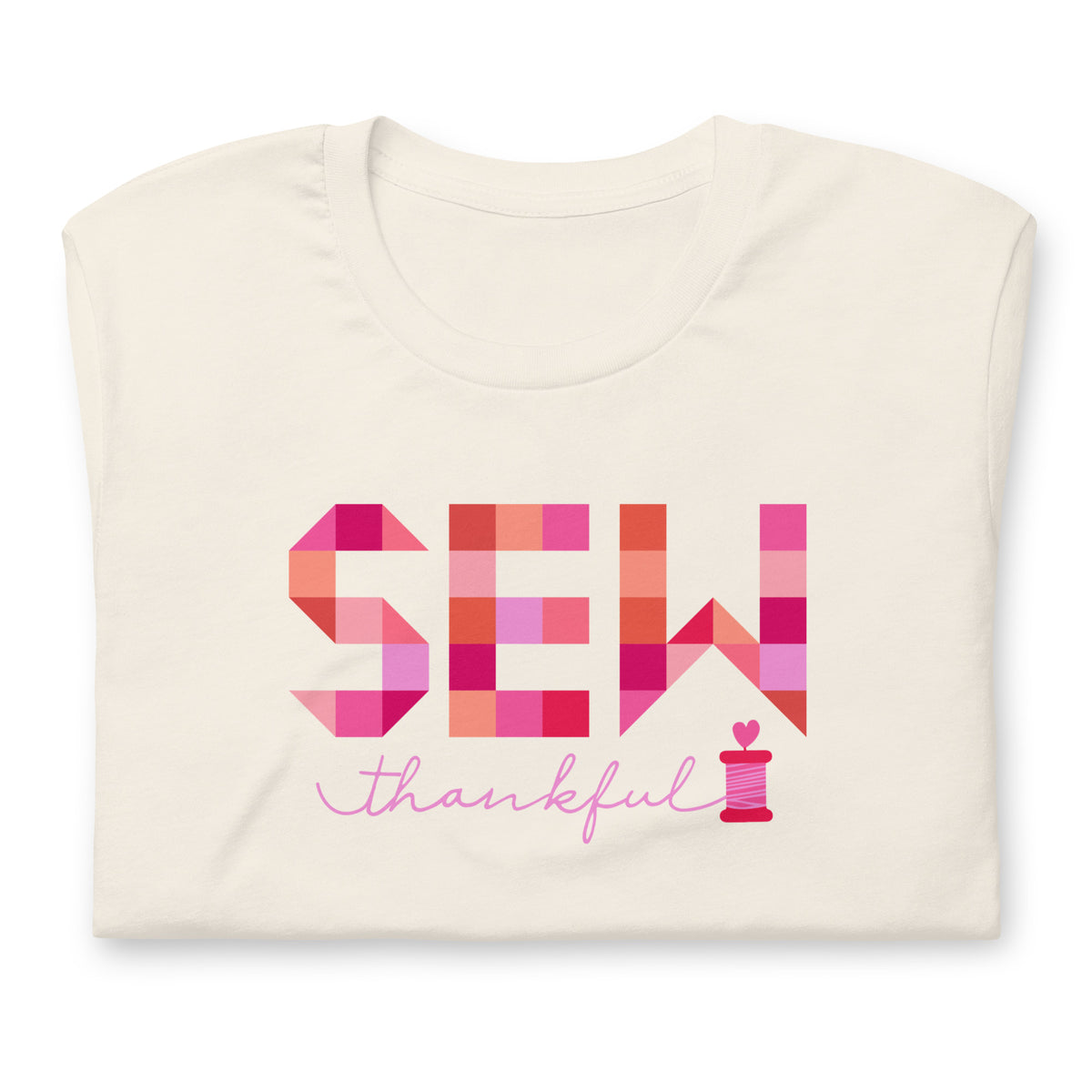 Sew Thankful patchwork lettering with a heart-topped thread spool on a t-shirt in vintage white, folded close-up of the design – Kate Spain design for Pat Sloan