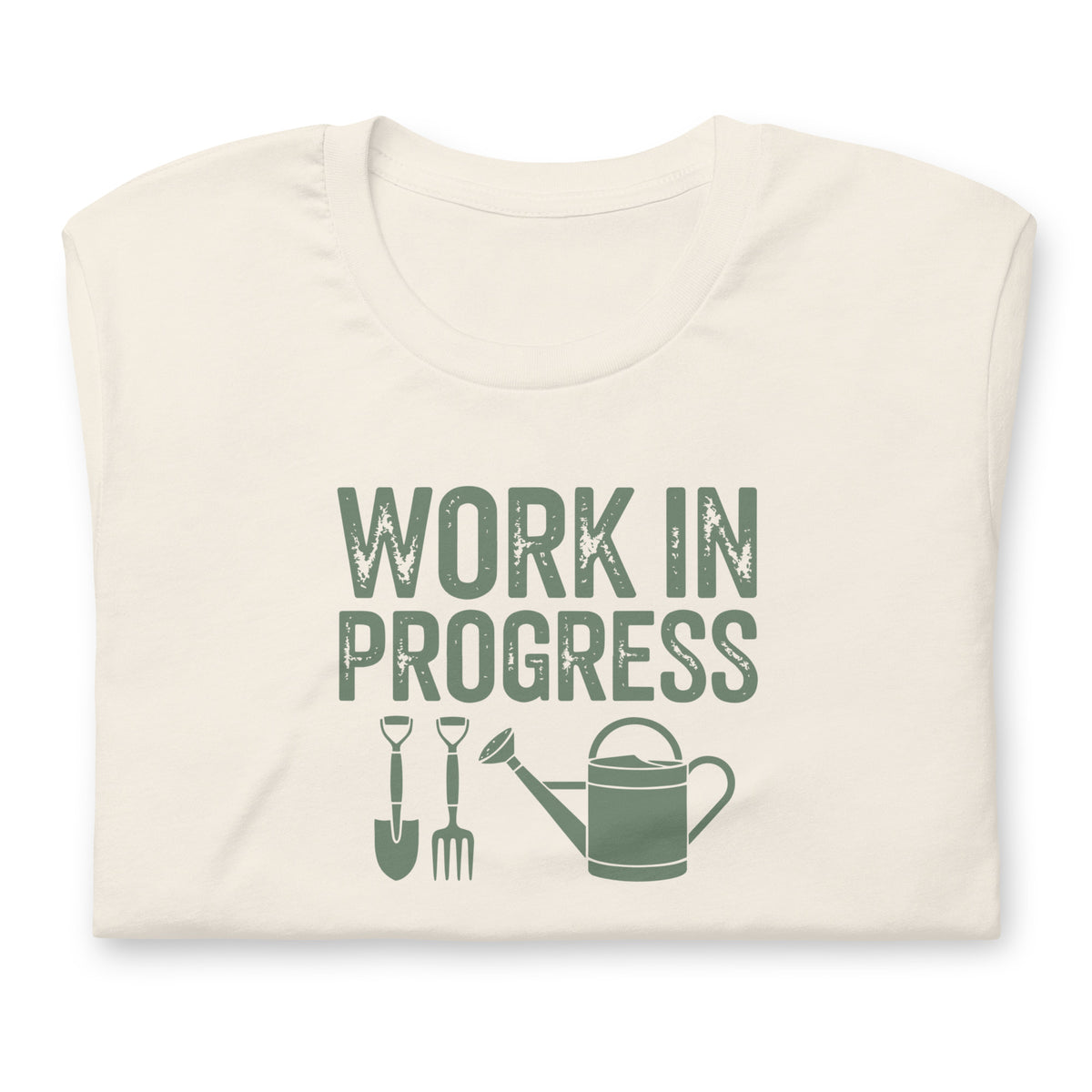 Garden Work in Progress distressed lettering with a shovel, pitchfork and watering can on a t-shirt in vintage white, folded close-up of the design – Kate Spain design
