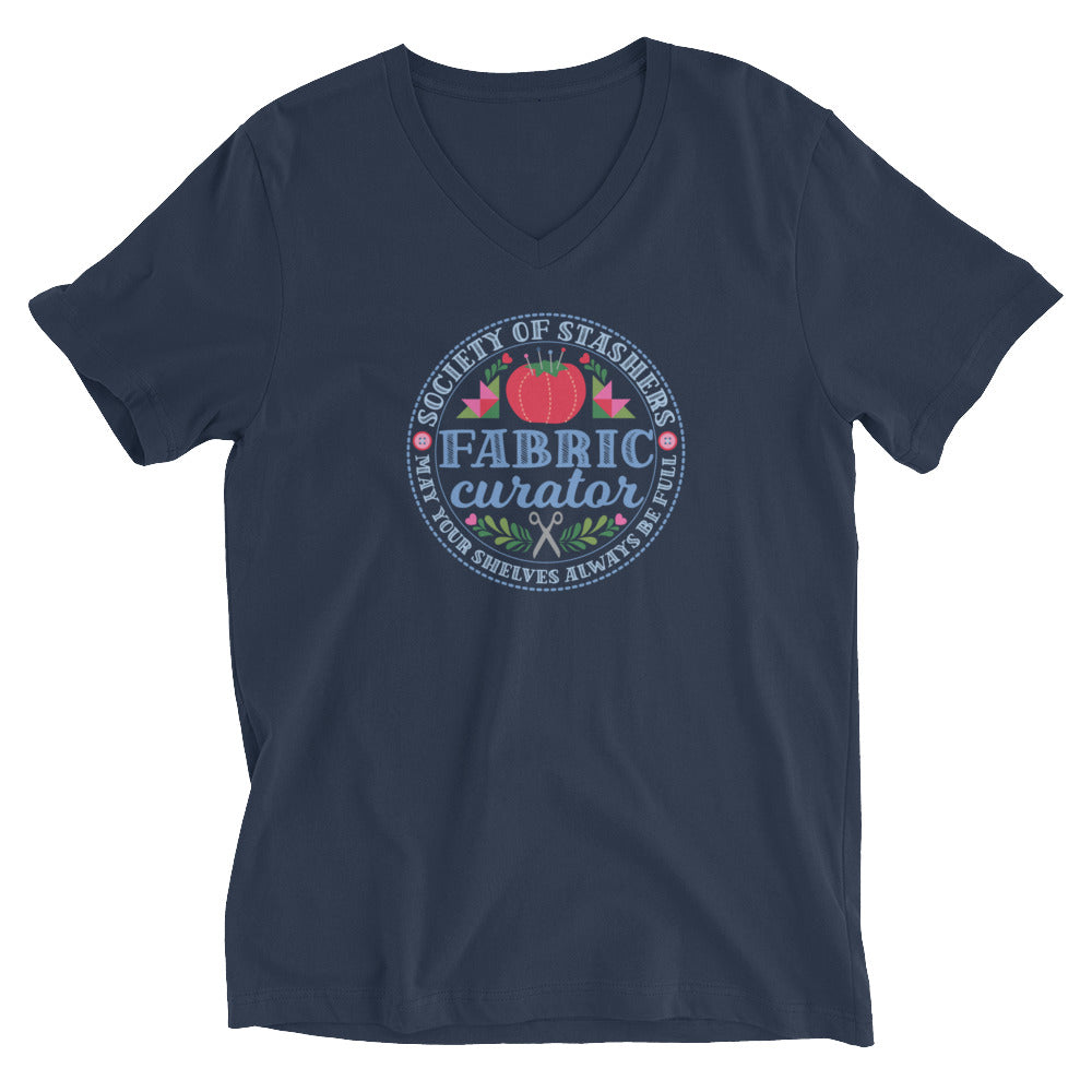 Fabric Curator Society of Stashers crest with a tomato pincushion on a unisex v-neck tee in navy, front view – Kate Spain design for Pat Sloan