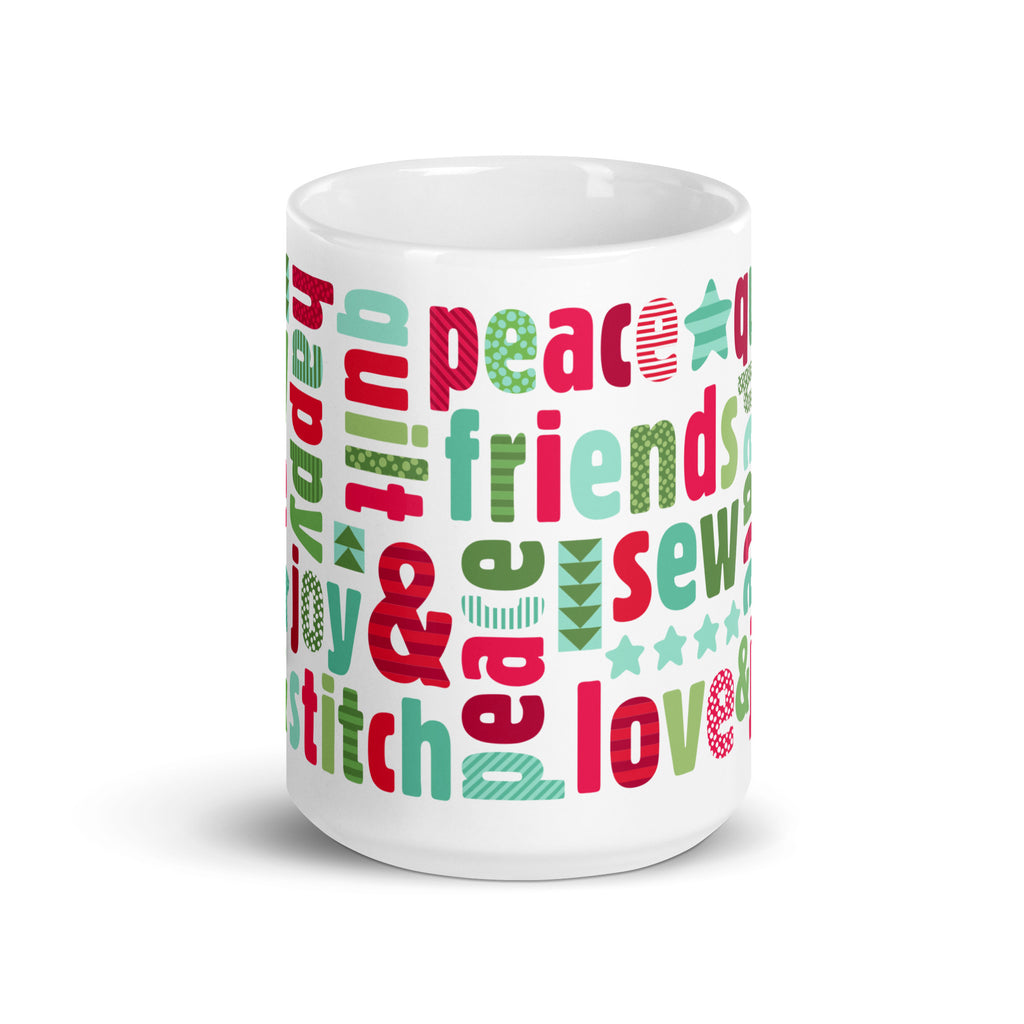 Happy Thoughts 15 oz ceramic mug wrapped in words like joy, peace, love, friends and quilt in red, green and aqua, front view – Kate Spain design for Pat Sloan