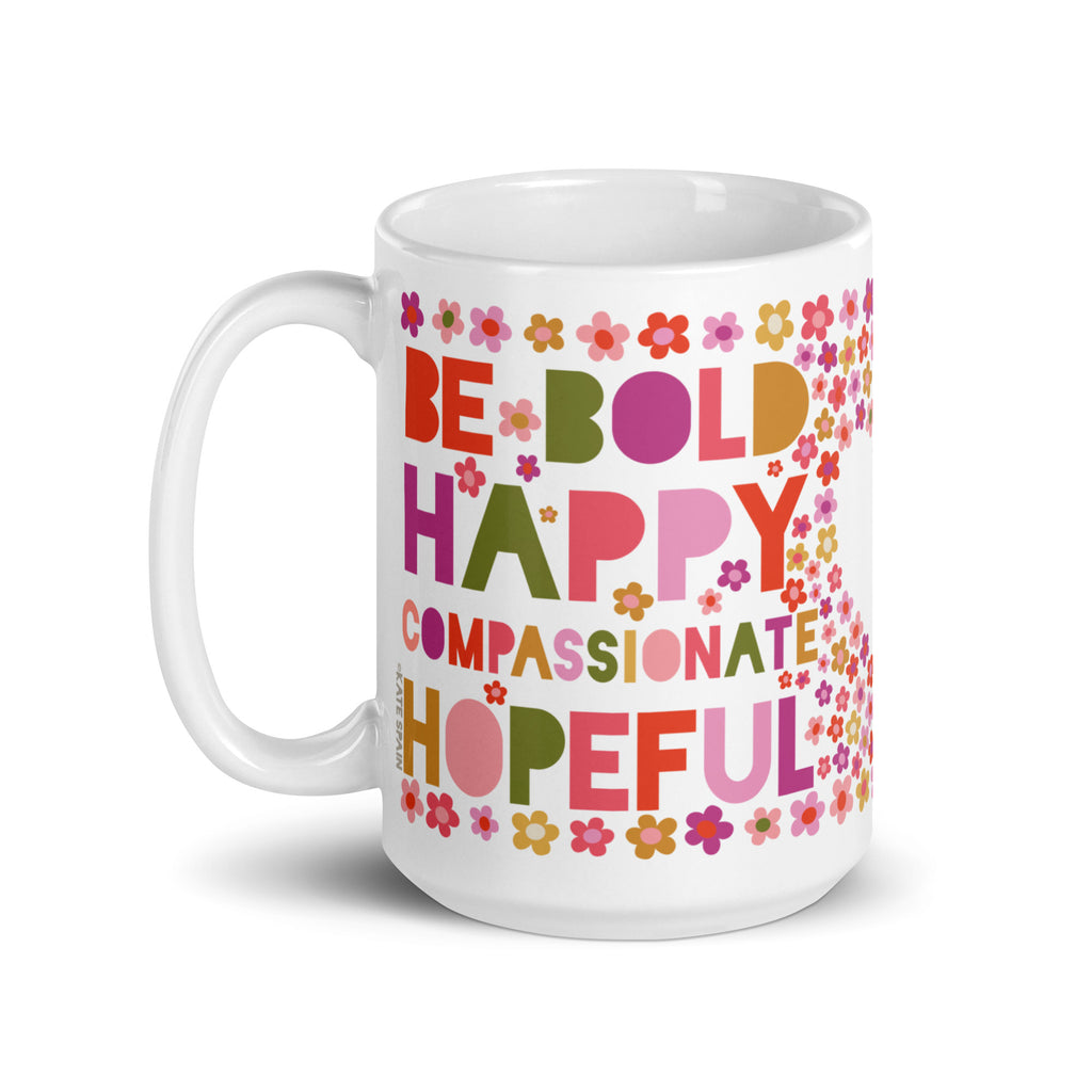 Be You 15 oz ceramic mug, handle on the left, reading “Be Bold, Happy, Compassionate, Hopeful” in colorful letters among tiny flowers – Kate Spain design