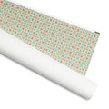 Talavera gift wrap, coral-red blooms and sage clover-leaf tiles on mint and cream, 30 by 36 inch matte paper, shown partly rolled – Kate Spain design