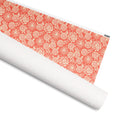 Simpatico gift wrap, cream and blush allium flowers and leaf sprigs on poppy red, 30 by 36 inch matte paper, shown partly rolled – Kate Spain design