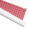Telluride gift wrap, cream Nordic snowflake diamonds on crimson, 30 by 36 inch matte paper, shown partly rolled – Kate Spain design