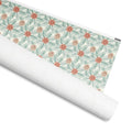 Pinecone gift wrap, pine-branch lattice with terracotta pinecones on cream, 30 by 36 inch matte paper, shown partly rolled – Kate Spain design